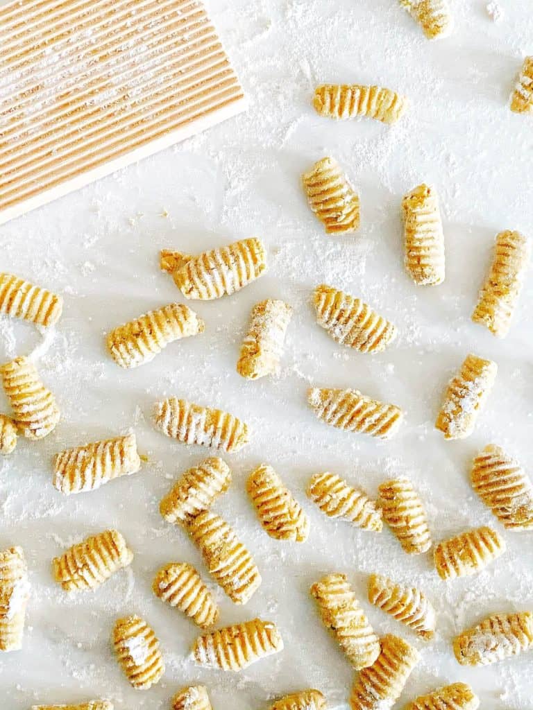 Sweet Potato Gnocchi on a white board with flour