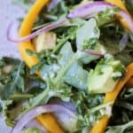 Close up image of Arugula Mango Avocado Salad on light brown speckled plateplate