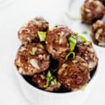 Bowl of AIP Beef Meatballs with chopped basil