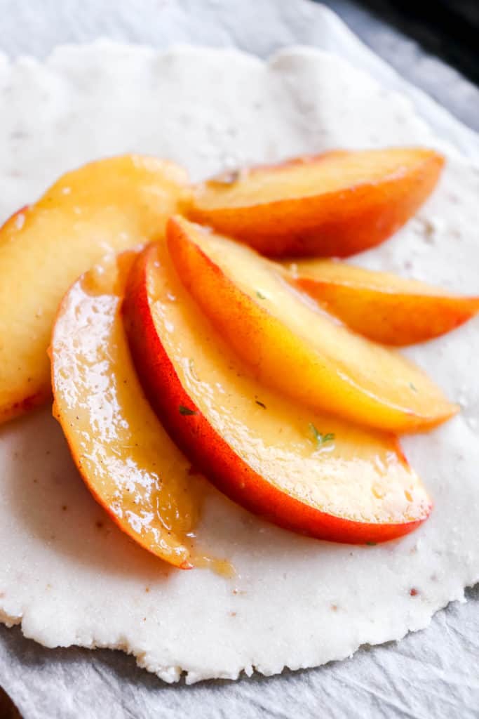 close up shot of peach galette with peaches arranged in a fan shape