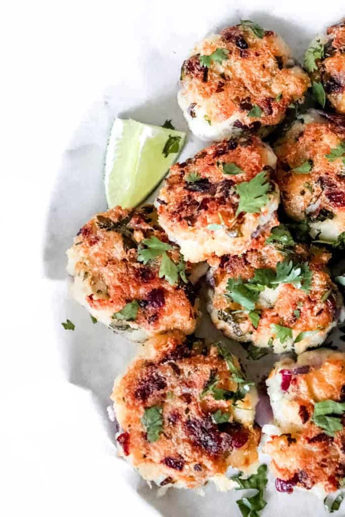 Cropped plate of AIP cod fritters with lime wedge