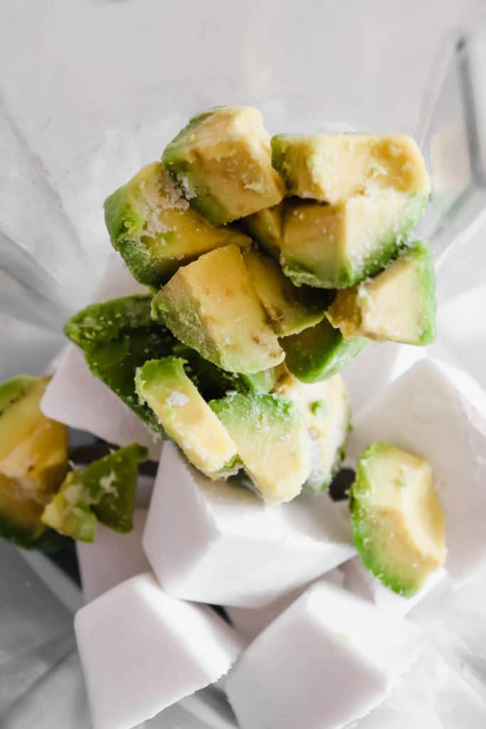 coconut milk ice cubes and frozen avocado in a blender