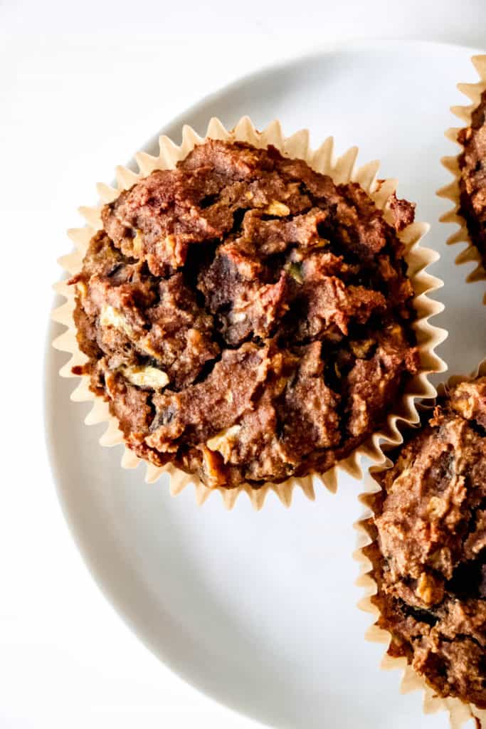 white plate with zucchini muffins in liners