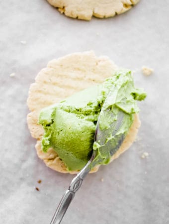 two cookies with a scoop of matcha ice cream and a spoon