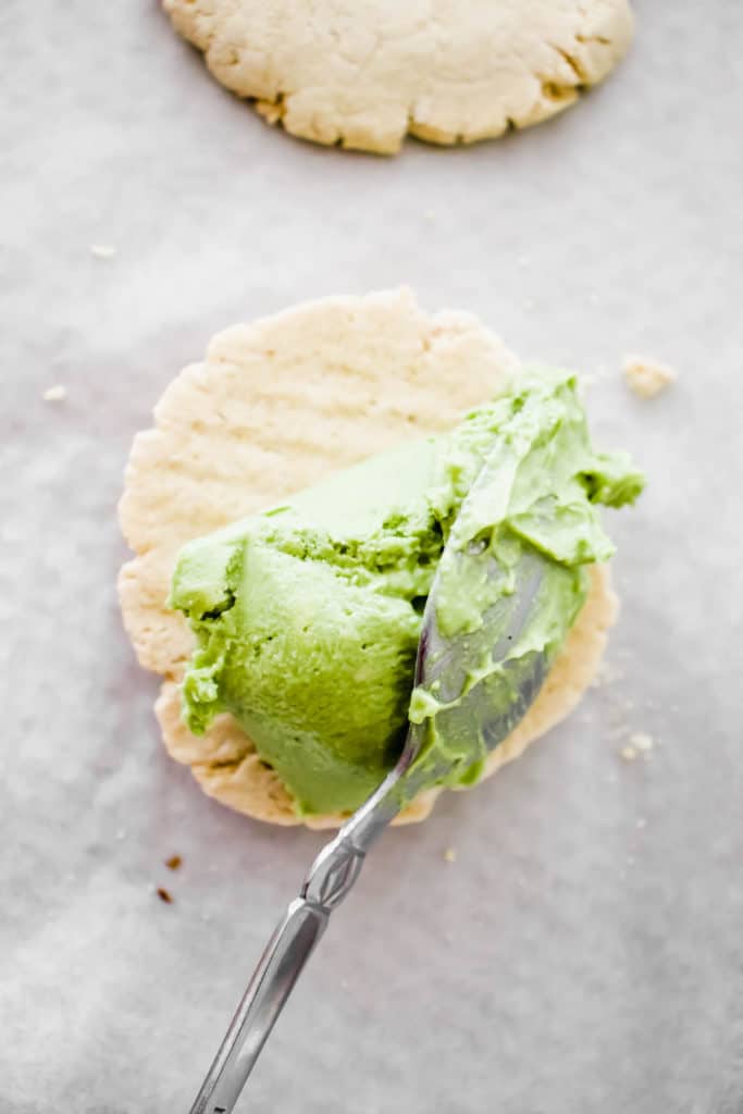 two cookies with a scoop of matcha ice cream and a spoon