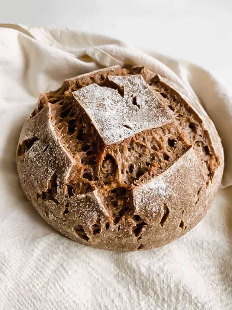 loaf of AIP Sourdough Bread on pale yellow tea towel