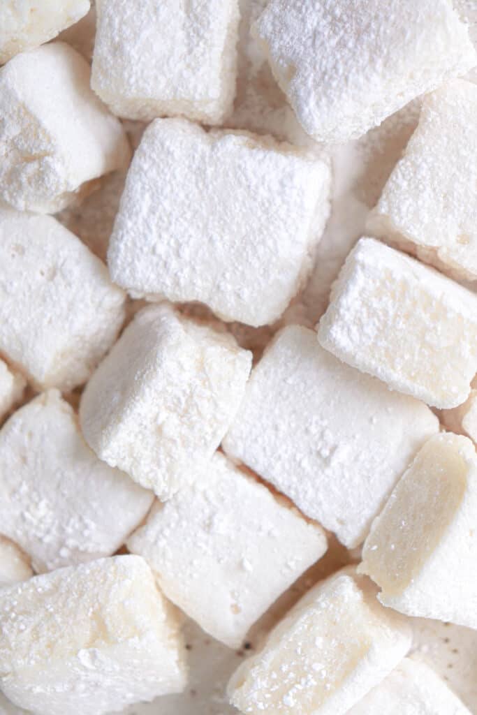 cream colored marshmallows dusted in tapioca starch on a beige plate