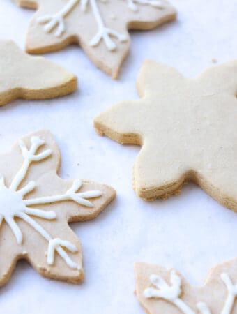 snowflake shaped cut out cookies on a white piece of parchment paper