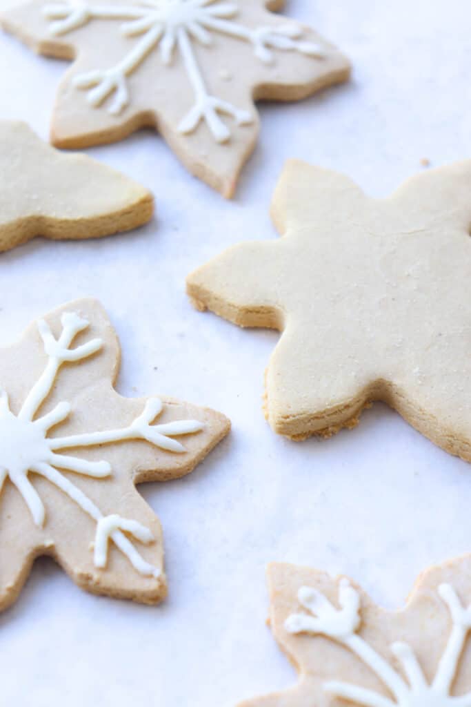 snowflake shaped cut out cookies on a white piece of parchment paper