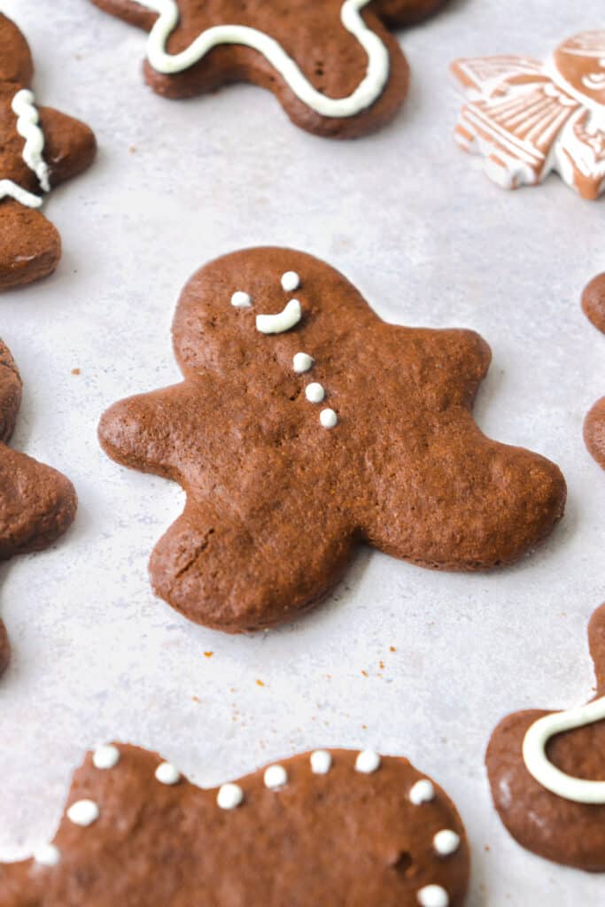 gingerbread people cookies iced with white icing on a grey background 