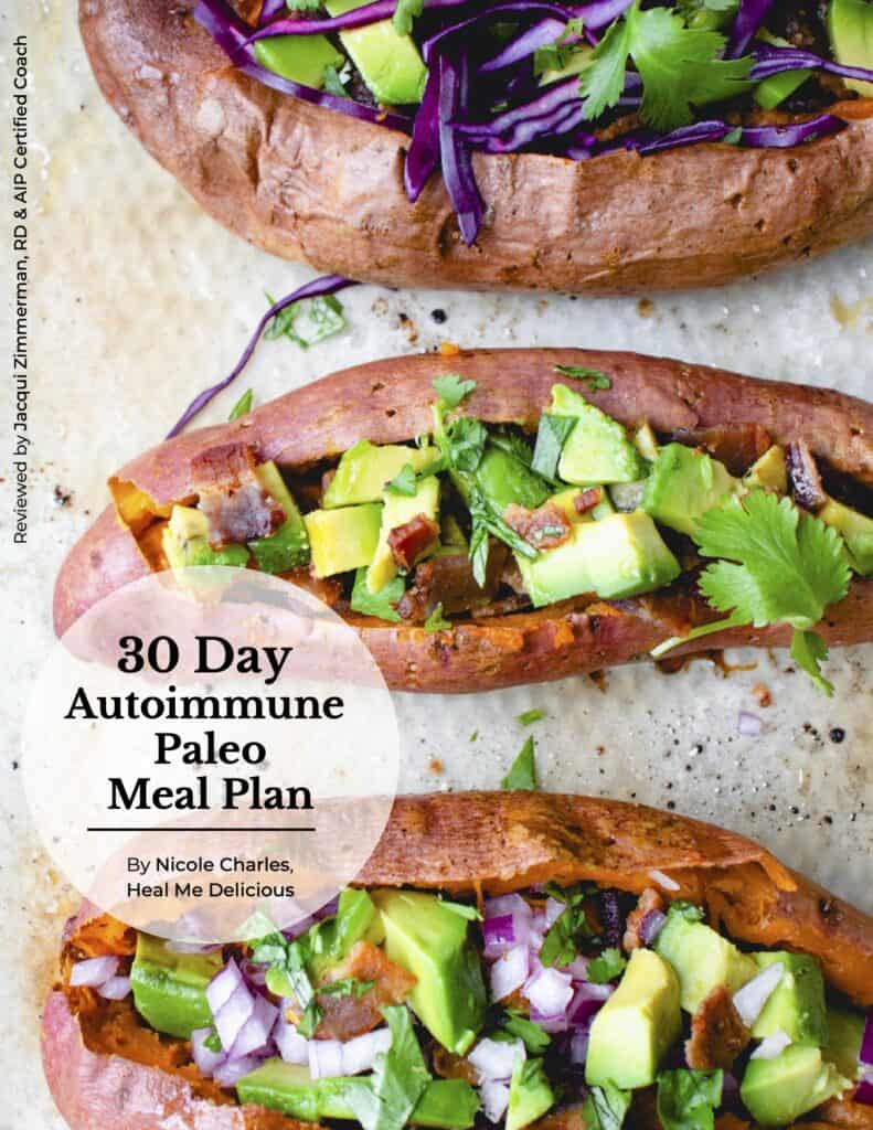 cover photo of 30 Day Meal Plan featuring an overhead shot of two orange sweet potatoes baked and stuffed with purple cabbage, cilantro, chopped avocados and bacon on a piece of parchment paper with the words 30 day autoimmune paleo meal plan written on top in black font inside a transparent white circle