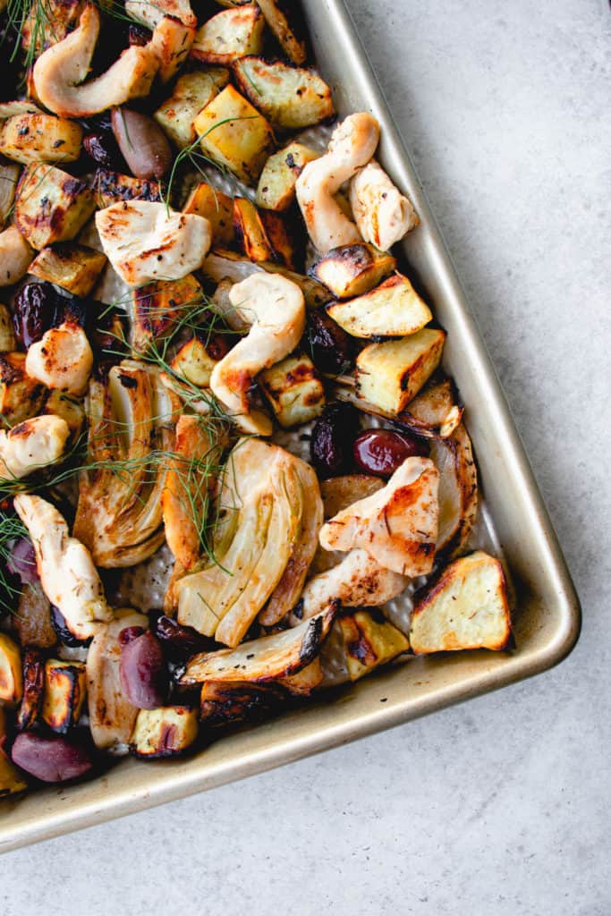 stainless steel sheet pan with chicken breast strips, kalamata olives, white sweet potatoes and pears garnished with fennel fronds