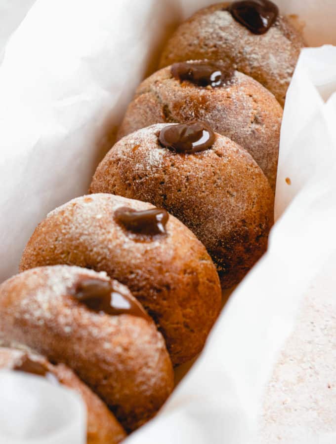 parchment lined bread pan filled with six mini donuts stuffed with salted caramel filling