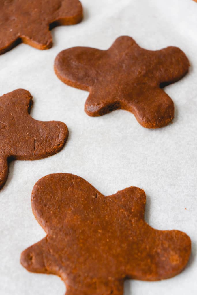gingerbread cookies, pre-baked on a white piece of parchment paper