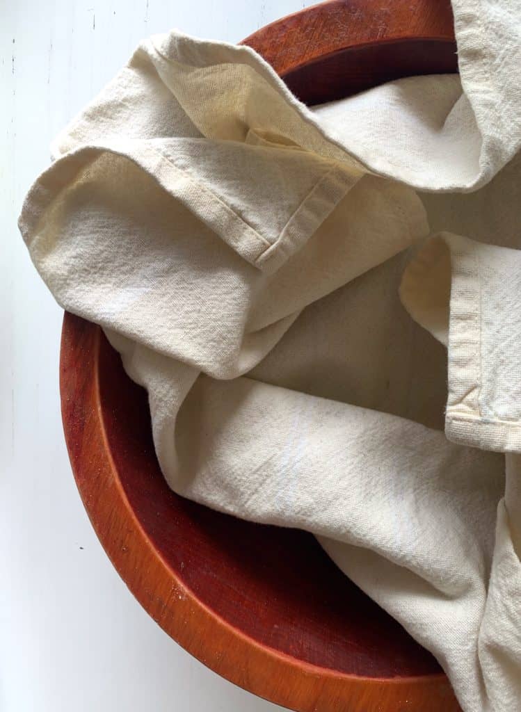 wood bowl and pale yellow tea towel