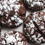 gluten free AIP/paleo chocolate crinkle cookies sprinkled with arrowroot starch on a piece of parchment paper