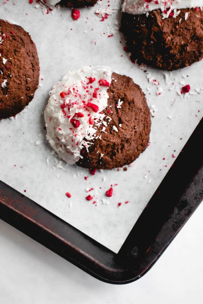 GF paleo chocolate peppermint cookies on white parchment paper on a dark baking sheet
