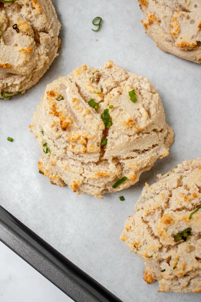 freshly baked gluten-free vegan drop biscuits on a baking sheet lined with parchment paper