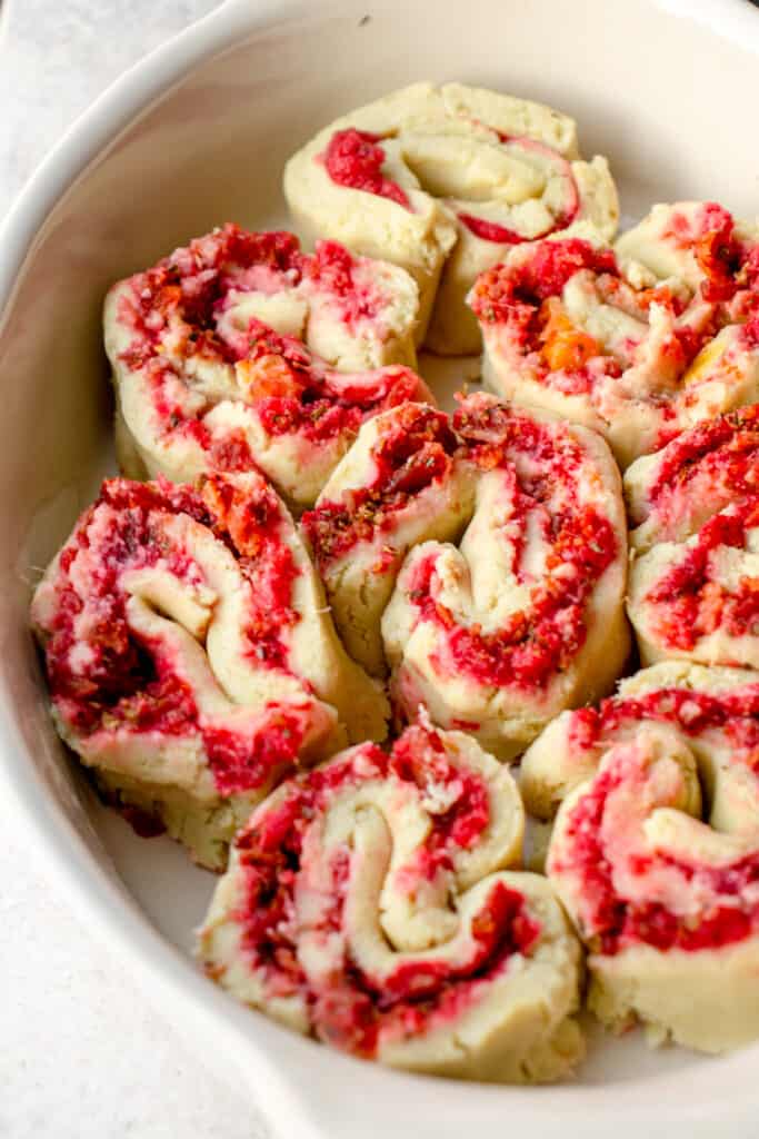 white oval casserole dish with pre-baked gluten free pizza rolls