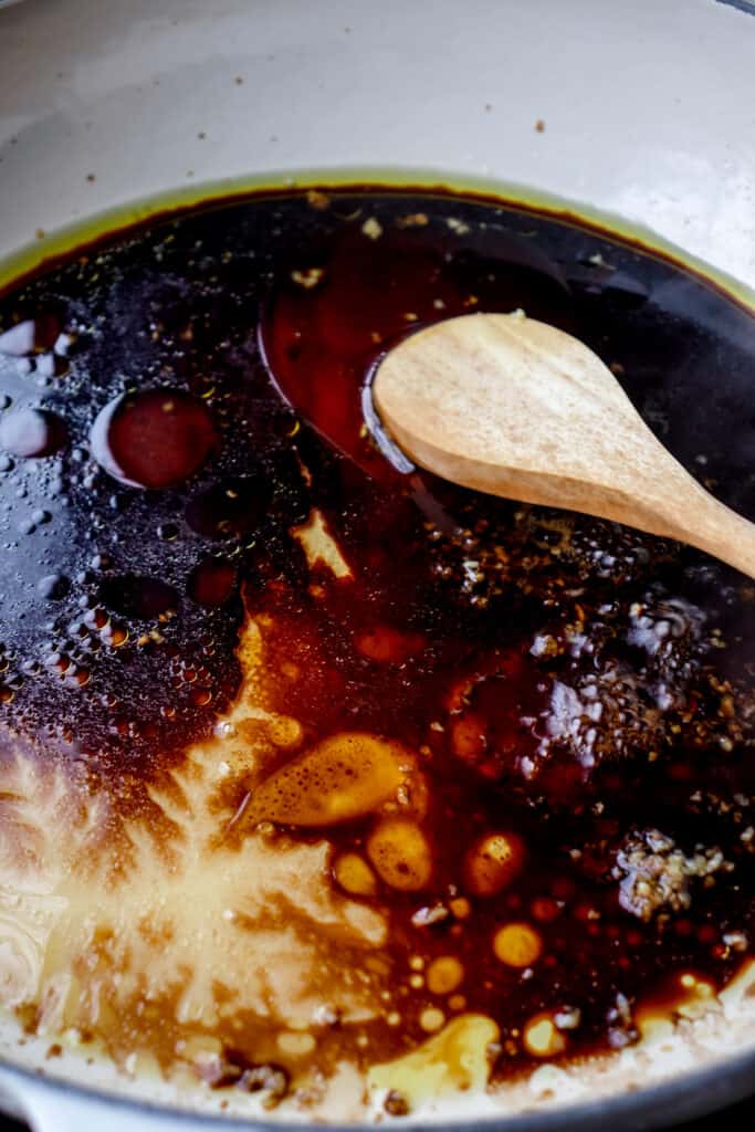 Process shot of honey garlic sauce being made in a saucepan.