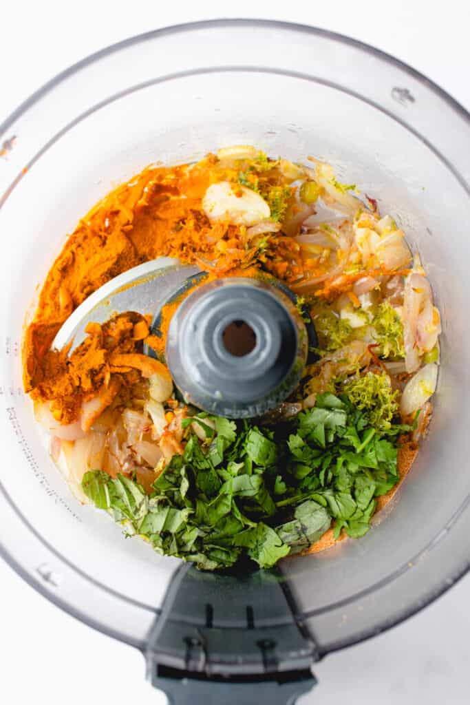Overhead shot of curry paste ingredients in a food processor.