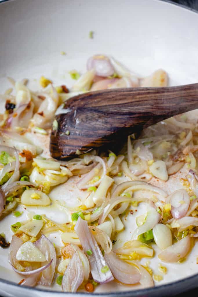 Shallots, garlic, ginger and lemongrass, sautéeing in a pan.