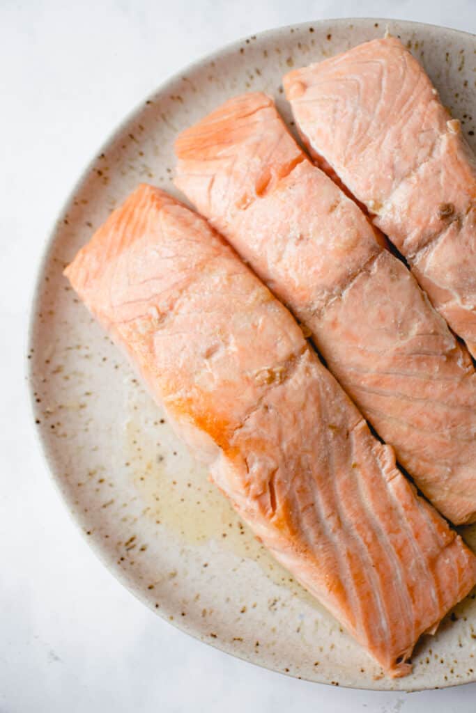 Pan-seared salmon, set aside on a plate.