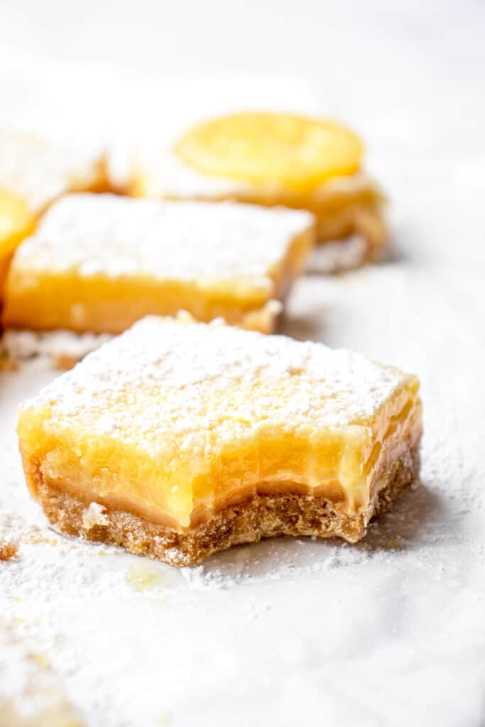 A close up shot of a bitten lemon bar to show the texture.