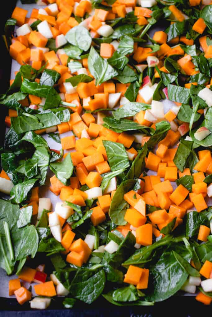 Sheet pan with seasoned veggies spread in an even layer