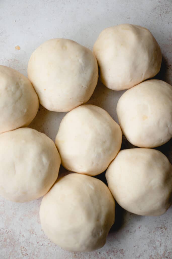 Eight balls of dough tightly clustered together.