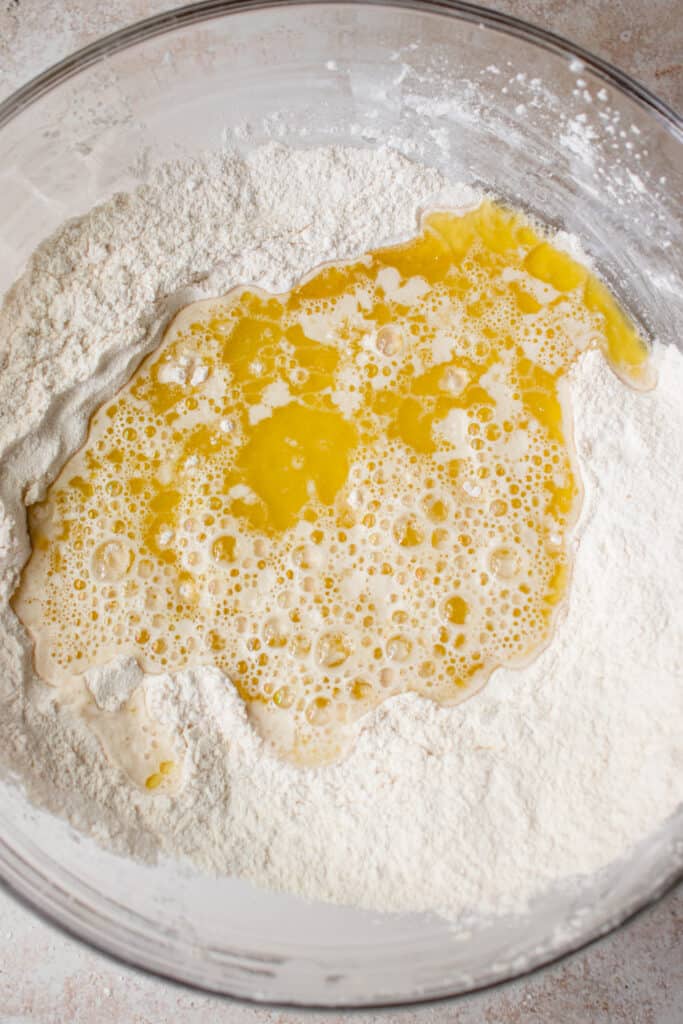 A glass bowl with cassava flour, tapioca starch, salt, garlic powder, olive oil and water.