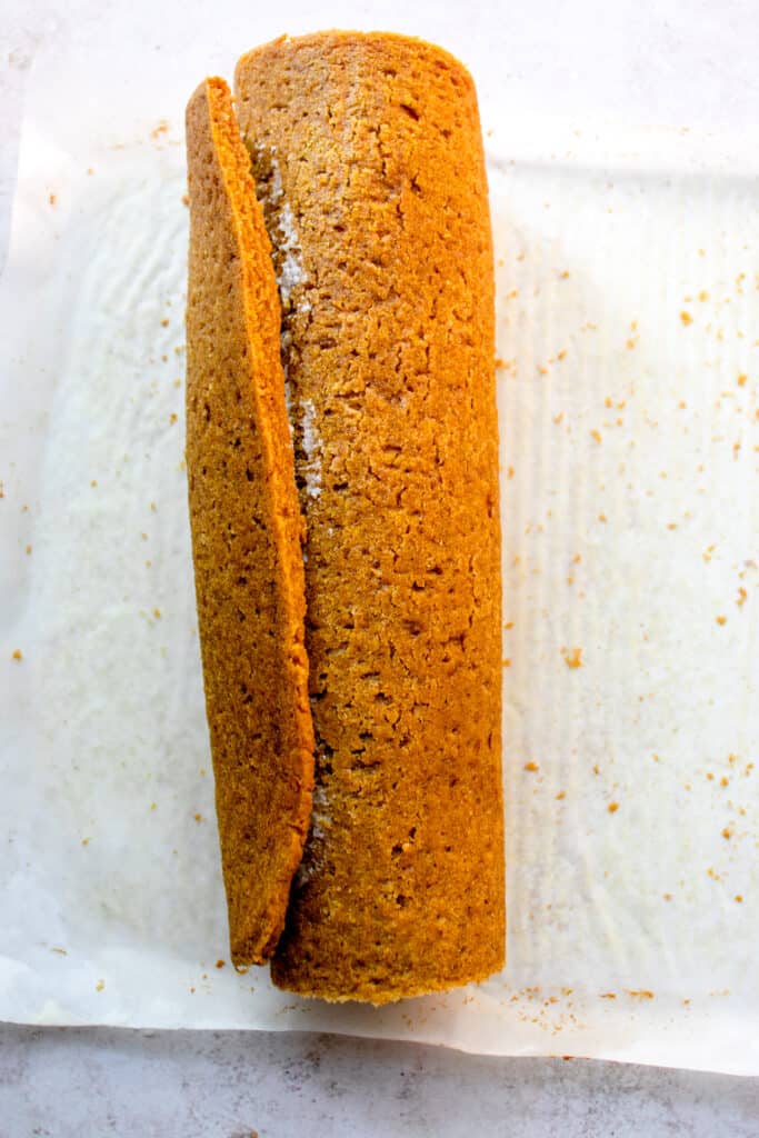 Gluten-free Dairy-free Pumpkin Roll, rolled up on a piece of parchment paper.