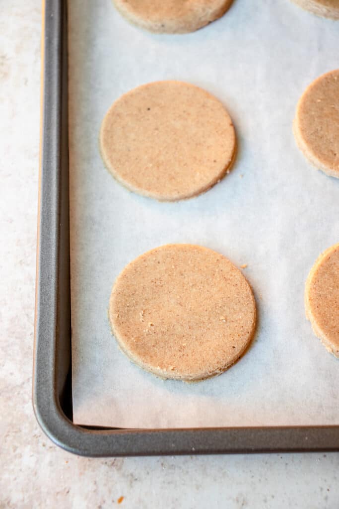 pre-baked cookies on a parchment-lined baking sheet