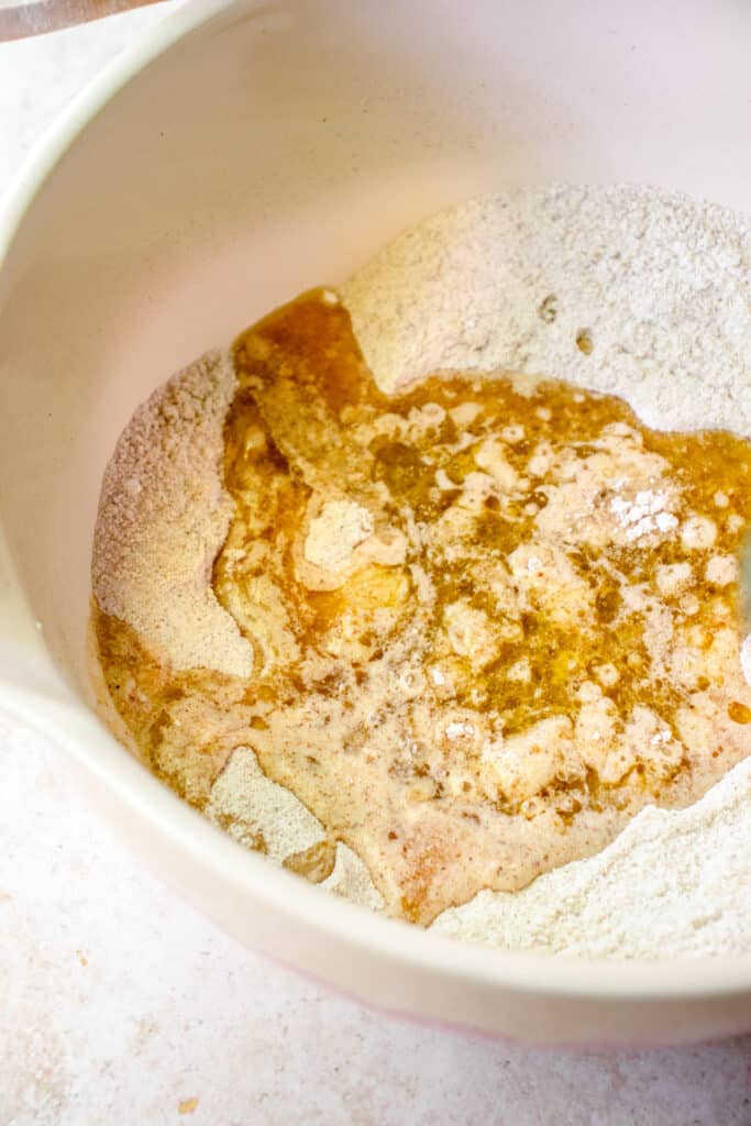 Large bowl with dry ingredients and wet ingredients poured into the center of it.