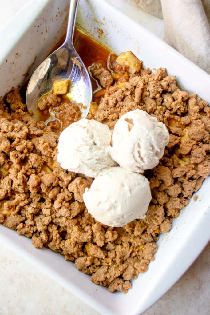 Baking dish of apple crumble with ice cream