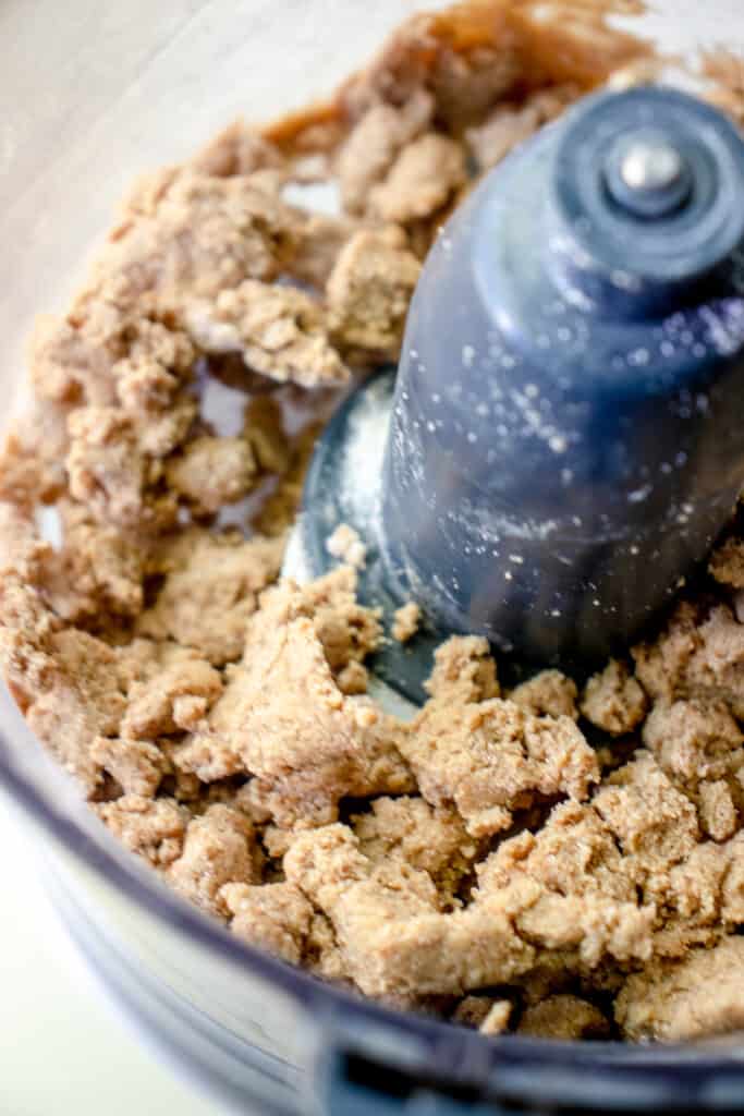 Pulsed crumble topping in a food processor showing the clumpy, crumbly pieces.