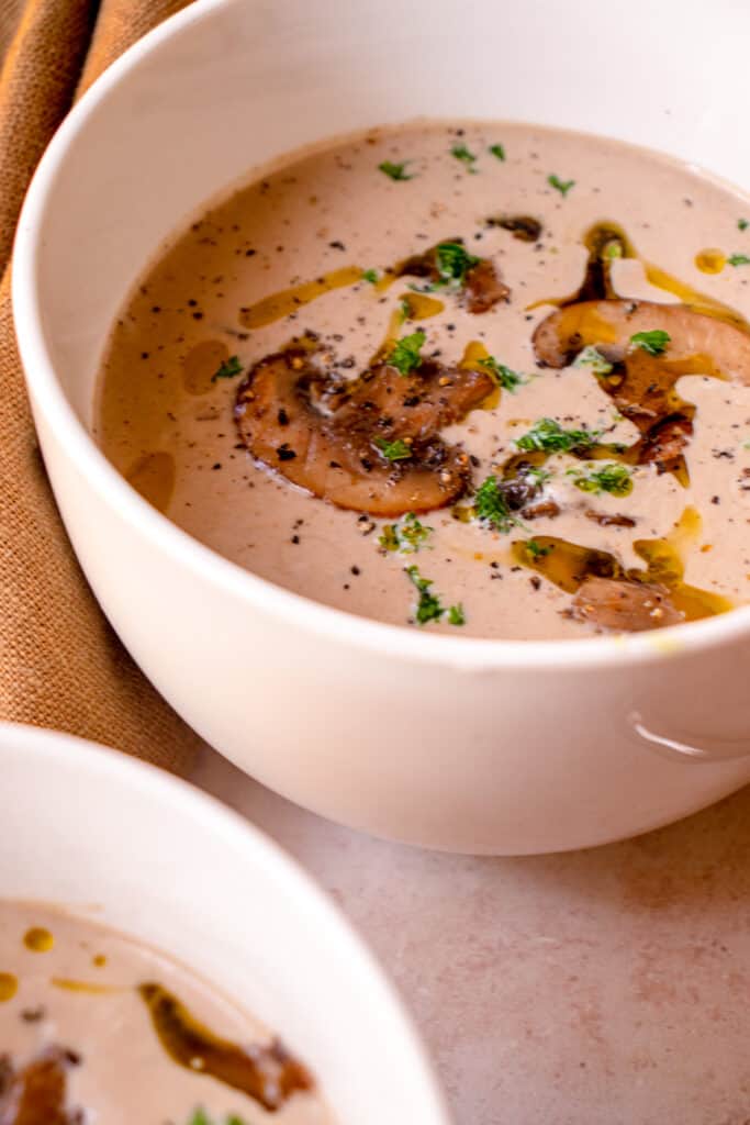 bowl of Gluten-Free Dairy-Free Cream of Mushroom Soup with optional garnishes.