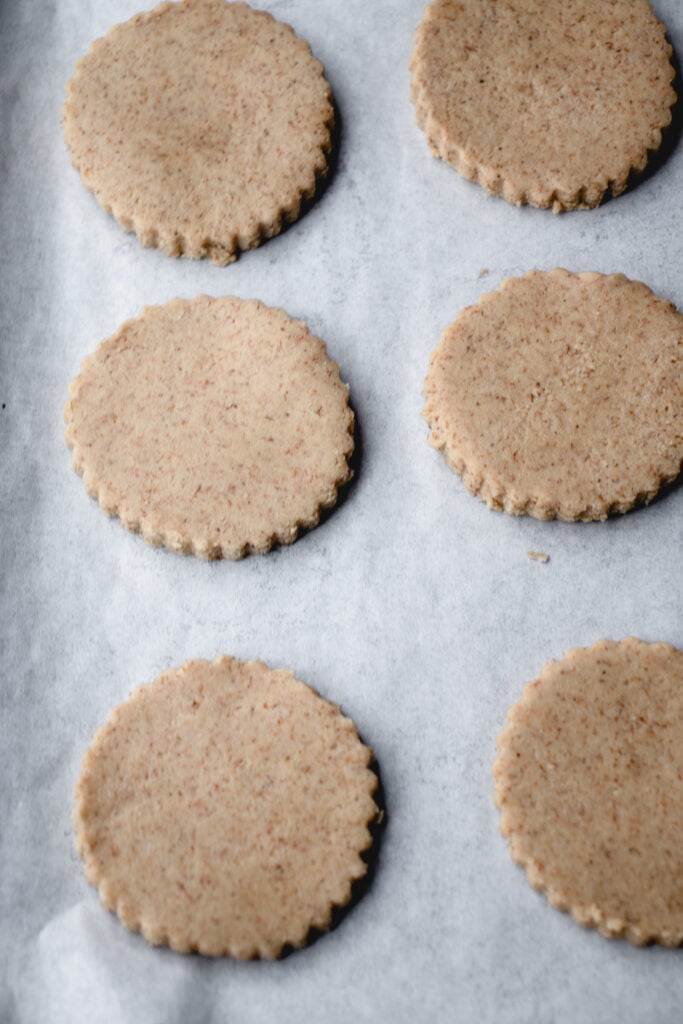 Cut out shortbread cookies on a sheet of parchment paper.