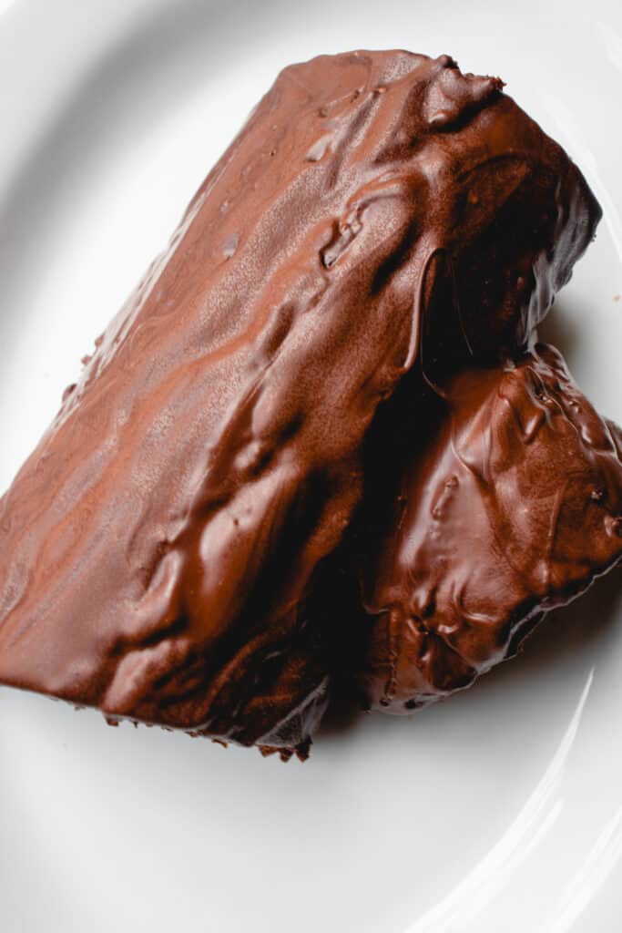 Cut yule log covered in hardened melted dairy-free chocolate.