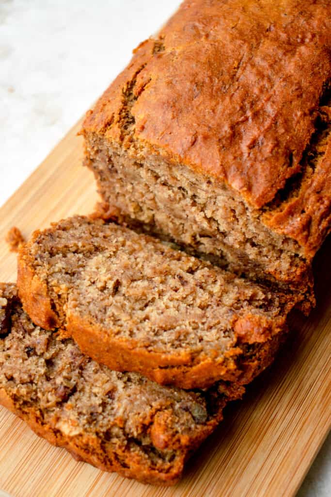 Vegan Gluten-Free Banana Bread atop a cutting board with two slices cut.