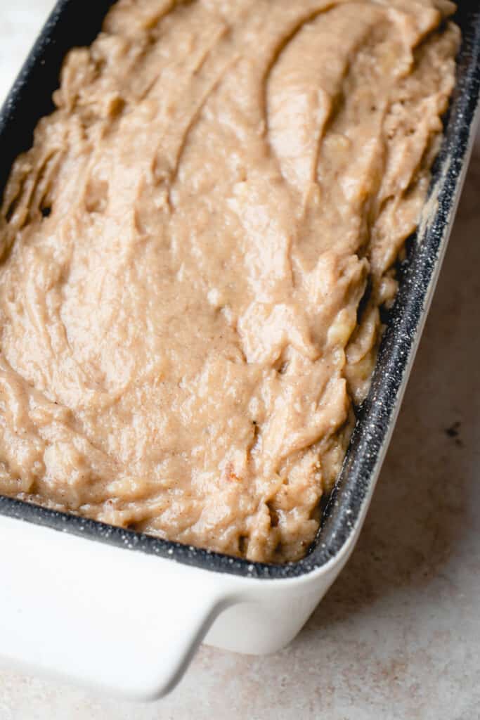 Banana bread batter poured into a loaf pan.