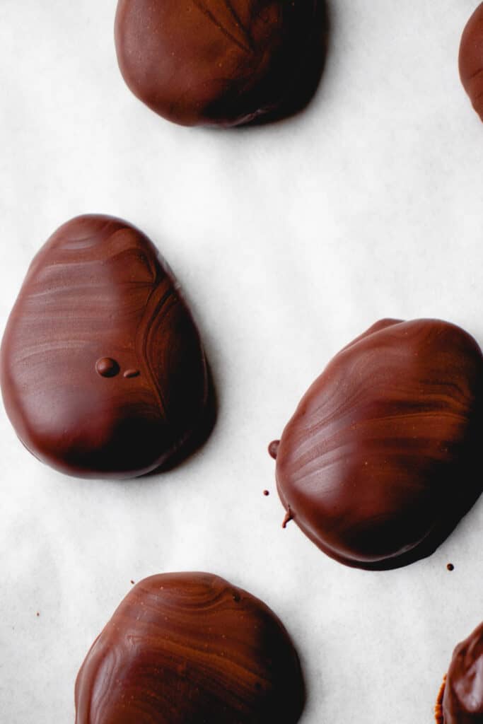 Chocolate covered eggs on parchment paper.