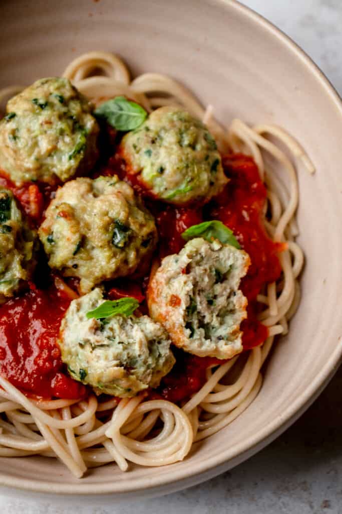 A plate with spaghetti, tomato sauce, and meatballs