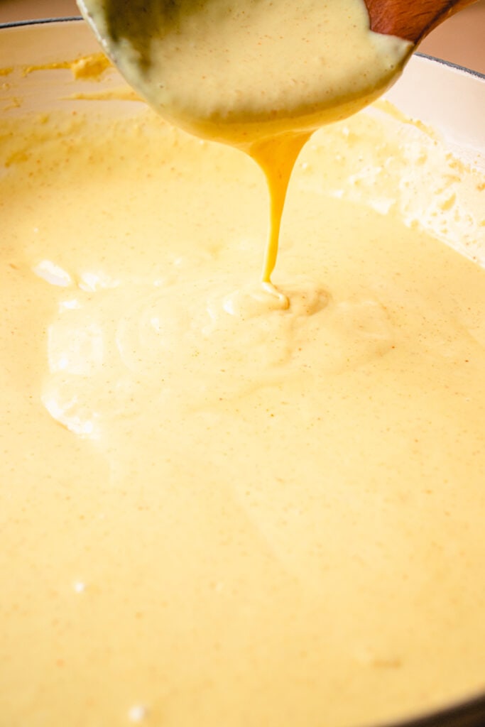 A skillet with Dairy-Free Cheese Sauce after the added tapioca slurry has been whisked in. 