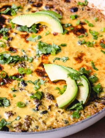 Easy Mexican Casserole garnished with avocado slices, chopped green onions and chopped cilantro.