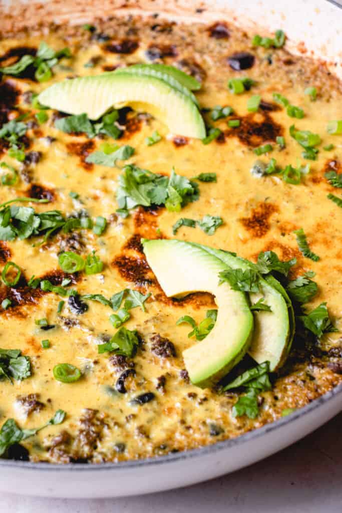 Easy Mexican Casserole garnished with avocado slices, chopped green onions and chopped cilantro.