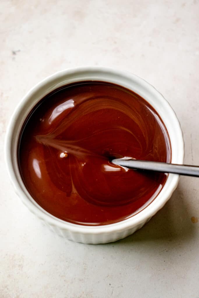 Melted dairy-free chocolate in a small bowl with a spoon.