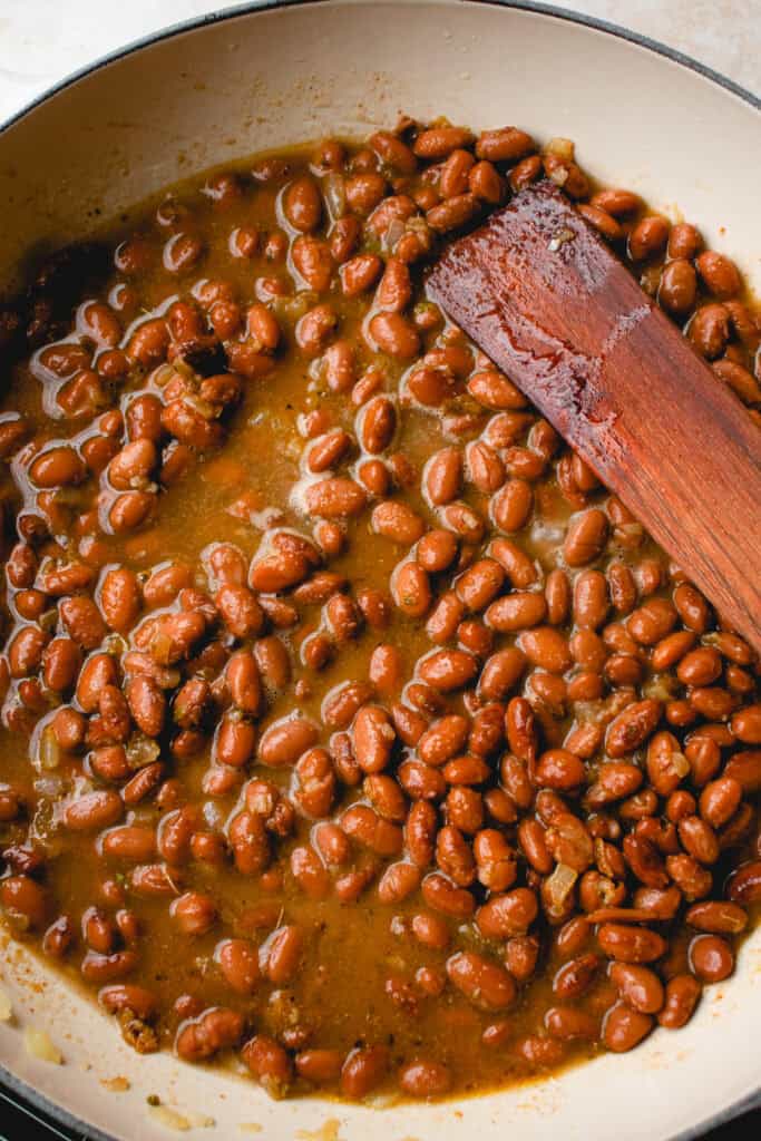 Pinto beans and water added to the onions and spices in the skillet.