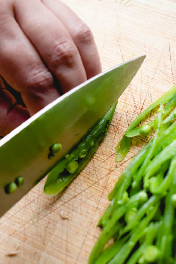 Close up of the process of cutting the snap peas.