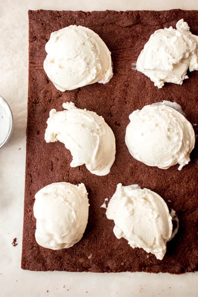 6 scoops of dairy-free vanilla ice cream on one piece of the chocolate sponge cake cookie.